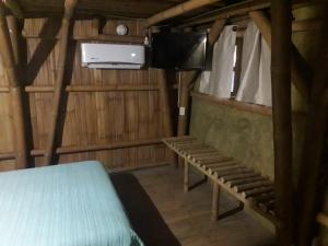 巴耶斯城Eco Hotel Casa Kima的一间配有电视的房间和一张位于房子内的床铺