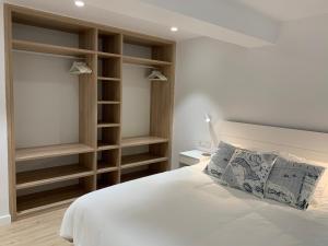 吉塔里亚Aldamar apartamentua PARKING INCLUIDO的卧室配有白色的床和木架