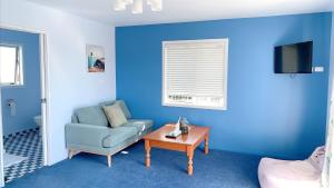 罗托鲁瓦Panoramic View Apartment Without a Kitchen的蓝色的客厅配有沙发和桌子