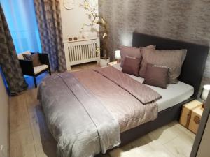 卢宾Apartament -Sweet Home的一间卧室配有一张大床和一把椅子