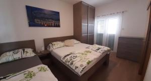 马卡尔斯卡Apartments Villa Ravlić的一间卧室设有两张床和窗户。