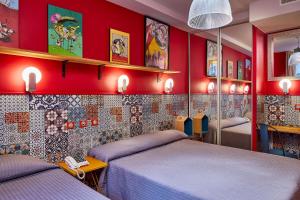 巴黎鲁贝酒店的红色墙壁客房的两张床