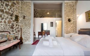 雅典A litte Taste of Home Guest House的卧室配有白色的床和砖墙