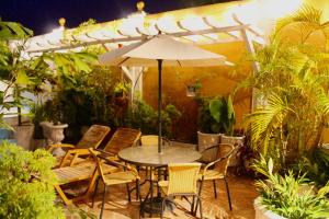 卡塔赫纳格罗里亚精品酒店的庭院配有桌椅和遮阳伞。