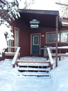 西黄石费斯街度假屋的雪中带蓝色门的红色小屋