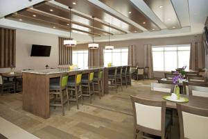 卡尔加里温德姆卡尔加里机场温盖特酒店的大型用餐室设有长条酒吧和椅子