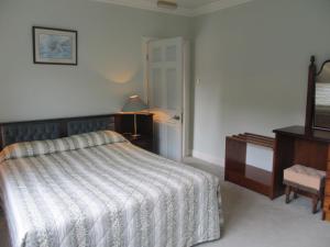 肯梅尔Neidin House的一间卧室配有一张床、梳妆台和电视。