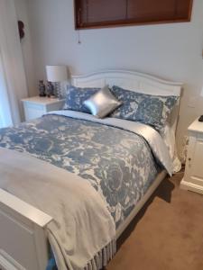 基督城哈伍德梅普尔斯住宿加早餐酒店的一间卧室配有一张带蓝色和白色棉被的床