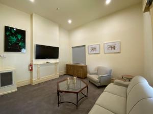 墨尔本St. Elizabeth's Home的带沙发和电视的客厅