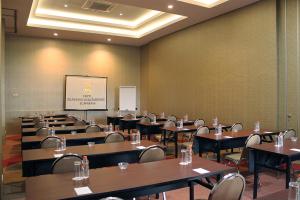 泗水格纳温萨梅尔酒店的一间会议室,配有桌椅和屏幕