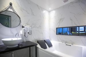 庆州Brown Dot Hotel Gyeongju的白色的浴室设有水槽和镜子