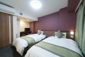 东京明神之汤神田尊贵多尔米酒店的酒店客房设有两张床和紫色墙壁。