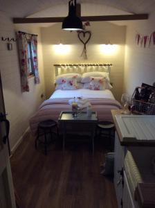 兰戈伦Llangollen Shepherds Huts的一间卧室配有一张大床和一张桌子