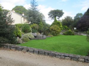 肯梅尔Neidin House的一座花园,花园内有石墙和绿色的草地