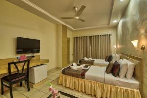 古瓦哈提维士瓦拉塔纳酒店的配有一张床和一台平面电视的酒店客房