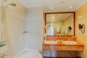 科布列季科布莱蒂格鲁吉亚宫殿度假酒店及Spa的浴室配有2个盥洗盆、淋浴和浴缸。