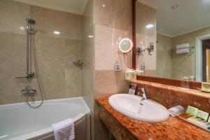 科布列季科布莱蒂格鲁吉亚宫殿度假酒店及Spa的浴室配有盥洗盆、浴缸和盥洗盆