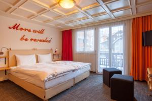 采尔马特安尼利斯小屋公寓酒店的一间卧室配有大床和红色窗帘