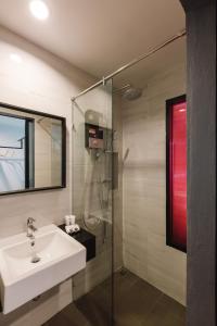 拉廊TOBEDzZ HOTEL的一间带水槽和玻璃淋浴的浴室