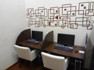 马瑙斯玛瑙斯假日酒店的办公室内两张桌子,配有电脑和椅子
