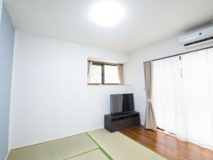 石垣岛Maruka石垣島的一间带电视和窗户的客厅
