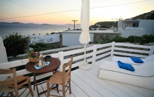 圣爱奥尼斯米科诺斯米科诺斯穆萨度假屋的阳台配有桌椅,享有海景。