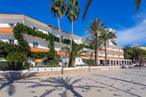 伊维萨镇菲格雷特斯酒店的一座棕榈树环绕的大建筑