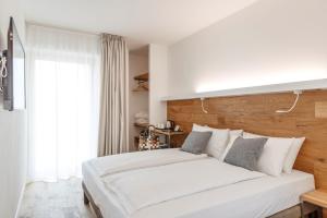 阿科ALEA - Garda Lake Suite的卧室设有一张白色大床和一扇窗户。