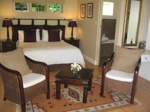 开普敦天堂自助小屋旅馆的一间卧室配有一张床、两把椅子和一张桌子