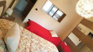 马里纳·迪·比萨Casa del Sole - Sunshine Home的一间卧室配有一张红色的床和吊灯。