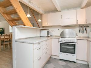 MosevråHoliday Home Grævlingevej II的厨房配有白色橱柜和白色家电