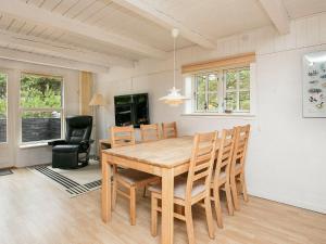 MosevråHoliday Home Grævlingevej II的一间带木桌和椅子的用餐室