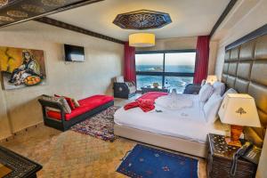 索维拉米莫纳摩洛哥传统庭院住宅的一间卧室配有一张大床和一张红色的沙发