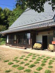 Ōuda楓 -Kaede-的院子内带门廊和两把椅子的房子