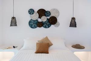 纳乌萨Zefi Hotel & Suites的卧室配有白色床,墙上挂着蓝色盘子