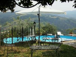Castello di SerravalleLa Buca的游泳池前的桌椅