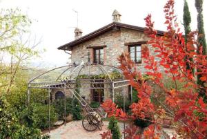 Castello di SerravalleLa Buca的花园内带凉亭的大型石屋