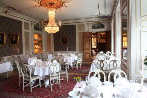 格内斯塔索德图纳城堡酒店的一间配备有白色桌椅和吊灯的餐厅