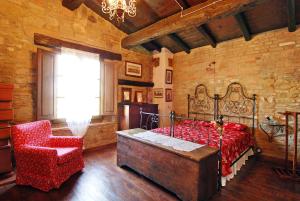 Castello di SerravalleLa Buca的卧室配有床、椅子和窗户。