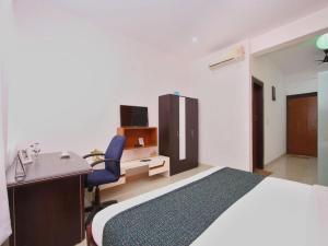 班加罗尔Airport Residency的一间卧室配有一张床、一张桌子和一把椅子