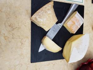 芒通橄榄树下酒店的一块奶酪和一把刀在切板上