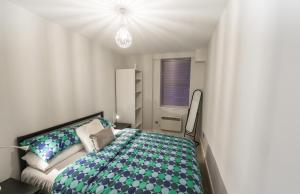 诺里奇Britannia House 1 bed apartment的一间卧室配有带绿色和白色枕头的床