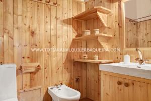 巴奎伊拉-贝莱特Apartamento Era Cascada By Totiaran的一间带木墙、卫生间和水槽的浴室