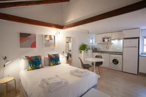 马德里Gran Central Suites的一间带白色大床的卧室和一间厨房