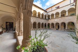 阿尔盖罗San Francesco Heritage Hotel的一座有柱子的建筑里的一个空的庭院