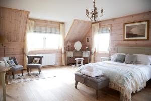 KemnayNetherton Farm Lodge的一间卧室配有一张床、一把椅子和窗户。