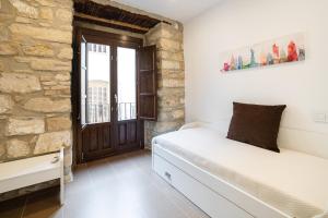 乌贝达Vivendas Turísticas SAN PABLO的卧室配有白色的床和石墙