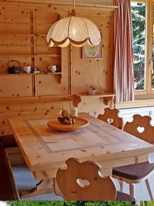 苏尔勒吉Chesa Rosatsch的木制房间内的一张木桌和椅子