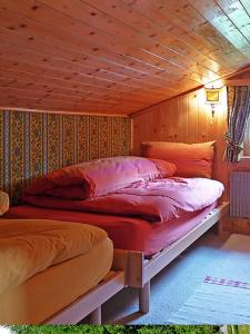 苏尔勒吉Chesa Rosatsch的卧室配有木墙内的两张床