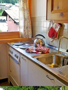苏尔勒吉Chesa Rosatsch的厨房柜台设有水槽和炉灶。